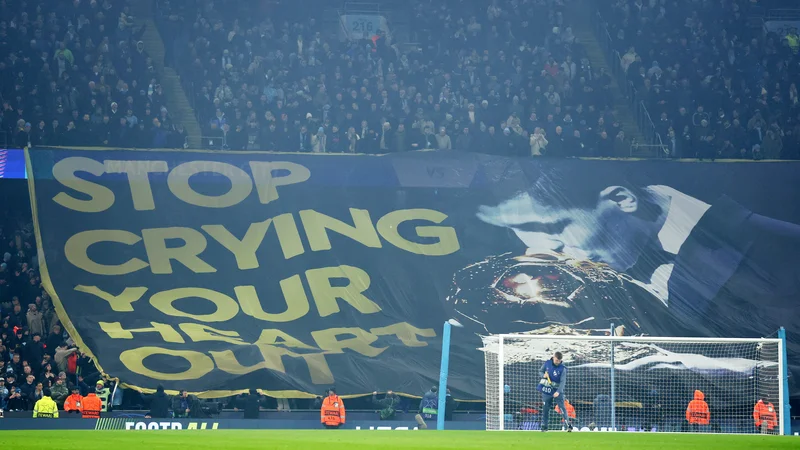 Navijači Manchester Cityja so zbodli Viniciusa s plakatom, na katerem je bil dobitnik zlate žoge Rodri. FOTO: Phil Noble/Reuters