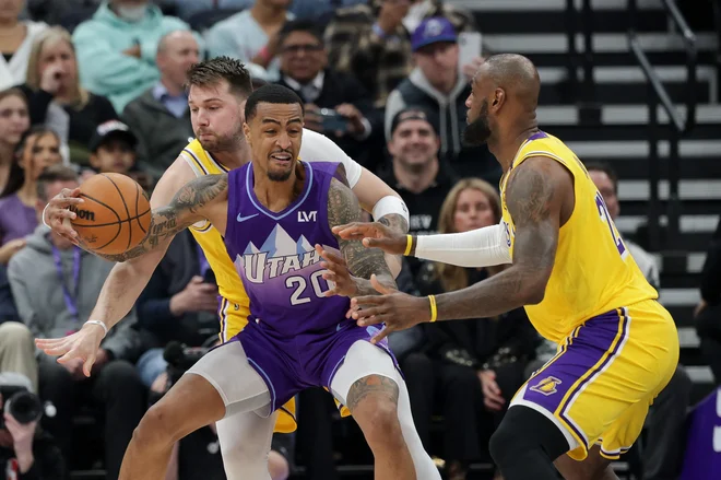 Dončić v obrambni akciji z LeBronom Jamesom. FOTO: Chris Nicoll/Reuters