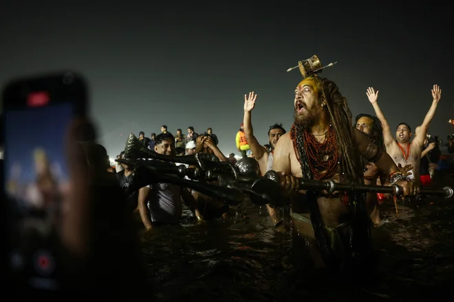 Hindujski svečeniki se namočijo v Sangam, sotočje rek Ganges, Yamuna in mitske reke Saraswati. med festivalom Maha Kumbh Mela v Prayagraju. Foto: Niharika Kulkarni/Afp