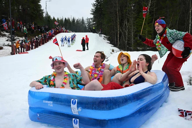 Navijači v bazenu navijajo za tekmovalke, ki tekmujejo v ženskem smučarskem teku na 20 km na svetovnem prvenstvu v nordijskem smučanju v Trondheimu na Norveškem. Foto: Jonathan Nackstrand/Afp