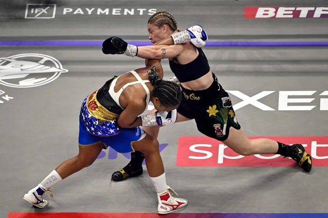 Lauren Price iz Walesa in Natasha Jonas iz Anglije si izmenjujeta udarce med dvobojem v velterski kategoriji po verzijah WBC, IBF in WBA v dvorani Royal Albert Hall v Londonu. Foto: Ben Stansall/Afp
