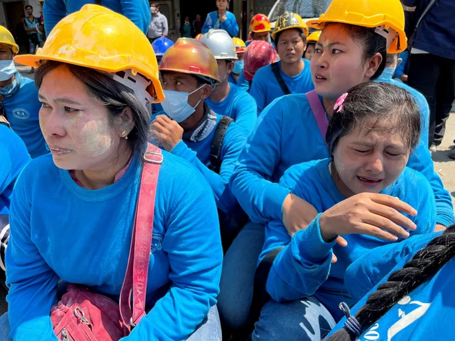 Delavci v Bangkoku v bližini zrušene stavbe. FOTO: Ann Wang/Reuters