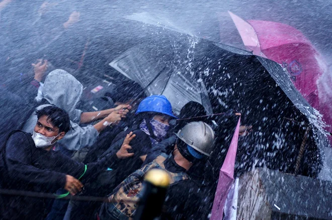 Policija z vodnimi topovi škropi protestnike med demonstracijami proti spremembi zakona o oboroženih silah pred poslopjem predstavniškega doma v Džakarti. Indonezijski parlament je 20. marca kljub protestom potrdil spremembo zakona o vojski, saj bo povečal vlogo oboroženih sil v civilnih zadevah. Cilj spremembe zakona o oboroženih silah, za katero si je prizadevala predvsem koalicija predsednika Prabowa Subianta, je bil razširiti vlogo vojske zunaj obrambe v državi. Foto: Azwar Ipank/Afp