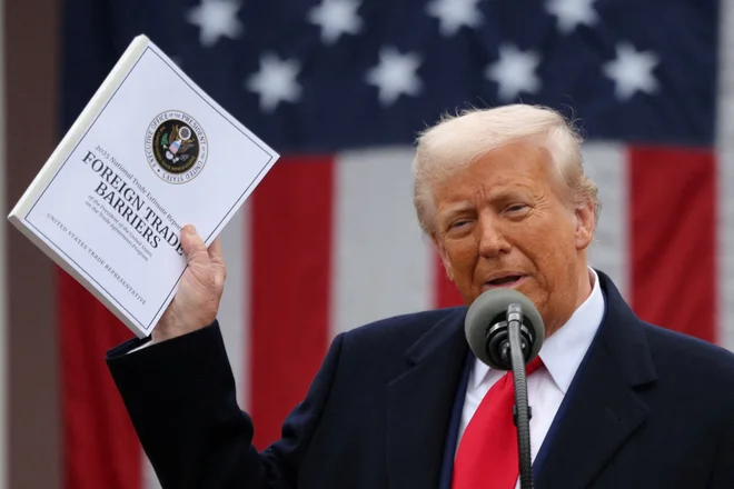 Ameriški predsednik Donald Trump je mahal s publikacijo z naslovom Tuje trgovinske ovire. FOTO: Carlos Barria/Reuters