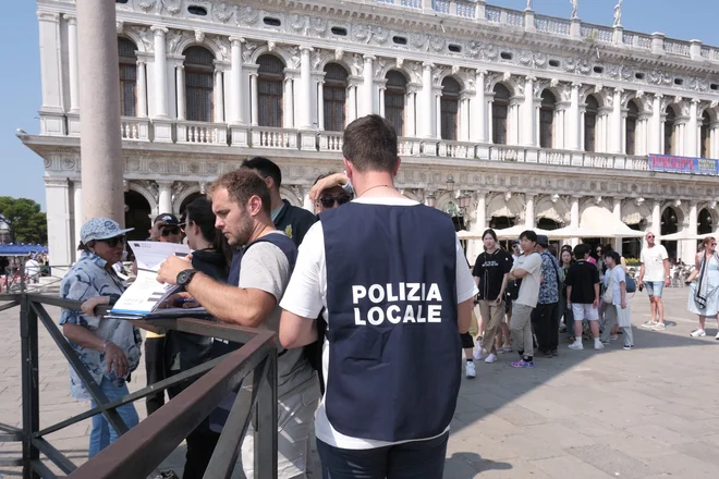 Obiskovalci z rezervacijo dobijo kodo QR, ki jo morajo pokazati redarjem na glavnih vstopnih točkah v mestu. FOTO: Manuel Silvestri/Reuters