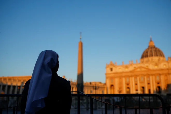 Gasilci so danes na vrh Sikstinske kapele začeli nameščati dimnik, ki ga bodo uporabljali med konklavom. FOTO: Reuters