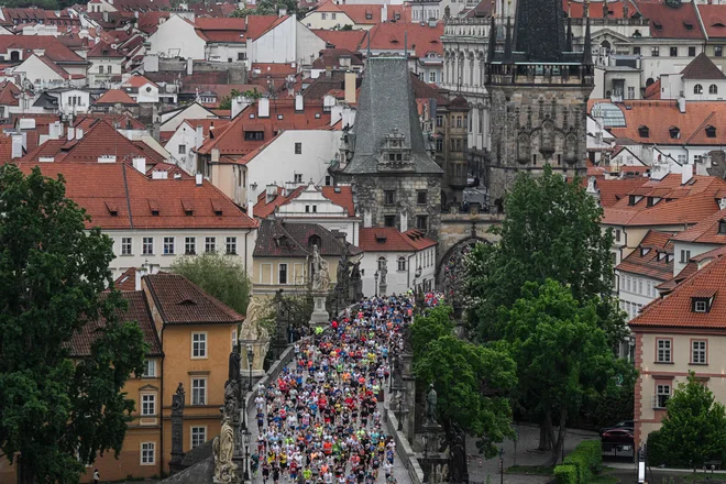Že tako turistov polno prestolnico Češke so včeraj še dodatno napolnili tekači z vsega sveta, a Karlov most na tej fotografiji z maratona ni bistveno bolj poln ljudi kot na običajen pomladanski dan. Foto Michal Cizek Afp