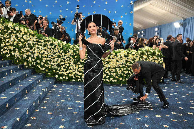Demi Moore, ki je pred kratkim blestela v filmu Substance, se je dobesedno oblekla v moško kravato v kiparski črno-beli črtasti obleki z bleščicami Thoma Browna. FOTO: Angela Weiss/AFP