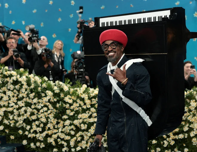 V enem izmed bolj nepozabnih videzov večera se je Andre 3000 pojavil na preprogi Met Gala s črno-belim klavirjem, pripetim na hrbet, in vrečko za smeti kot torbico. Elegantni raper OutKast je videz oblikoval sam v sodelovanju z Burberryjem. FOTO: Mario Anzuoni/Reuters