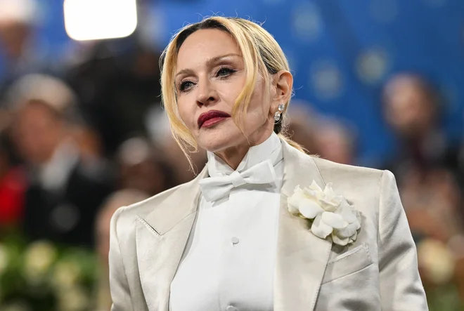 Pop legenda Madonna je svoj smoking dopolnila s cigaro in ustvarila preplet med mehkimi ženstvenimi materiali in izrazito moško energijo. To je dinamika, s katero se je zvezdnica igrala vso svojo kariero, je zapisal BBC. FOTO: Angela Weiss/AFP