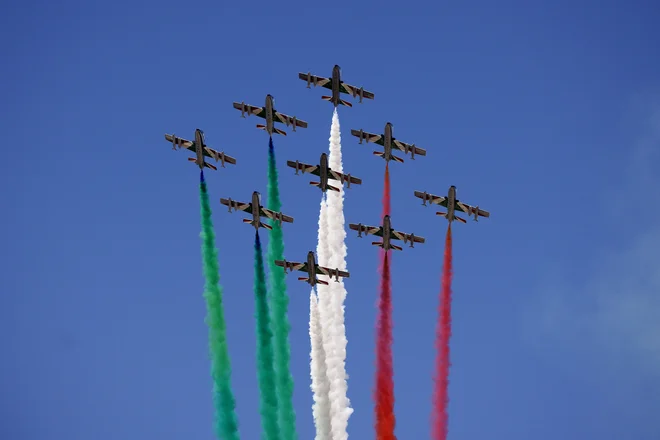 Skupina Frecce tricolori je znana po akrobatskih letih, med katerimi za letali ostajajo značilne sledi v barvah italijanske zastave. FOTO: Guglielmo Mangiapane/Reuters