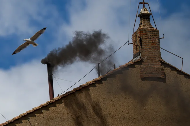 Črni dim iz dimnika nad Sikstinsko kapelo. FOTO: Hannah Mckay/Reuters