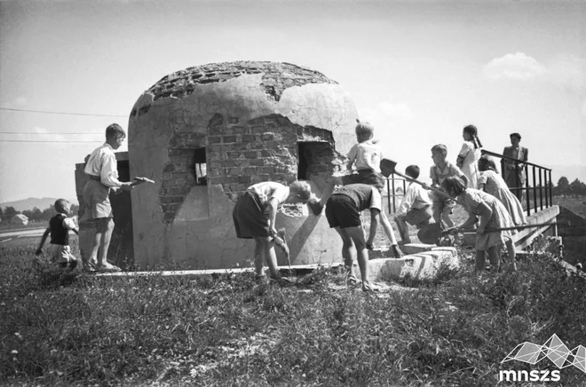 Otroci na »udarniško nedeljo« 9. septembra 1945 rušijo bunker na nasipu nekdanje obvozne proge Dravlje–Vodmat (danes na prehodu Vodovodne ceste čez progo Ljubljana–Kamnik). Fotografijo hrani Muzej novejše in sodobne zgodovine Slovenije. FOTO: Marjan Pfeifer
