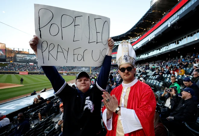 Novica o njegovem navijaštvu je nekatere privržence White Sox celo tako prevzela, da so se, kot poročajo ameriški mediji, na eno izmed naslednjih tekem svoje ekipe odpravili oblečeni v stilizirana papeška oblačila, drugi pa so na tribune prinesli plakate s hudomušnimi prošnjami, naj papež Leon XIV. moli za njihovo (in svojo najljubšo) ekipo. FOTO: Carlos Osorio/Reuters