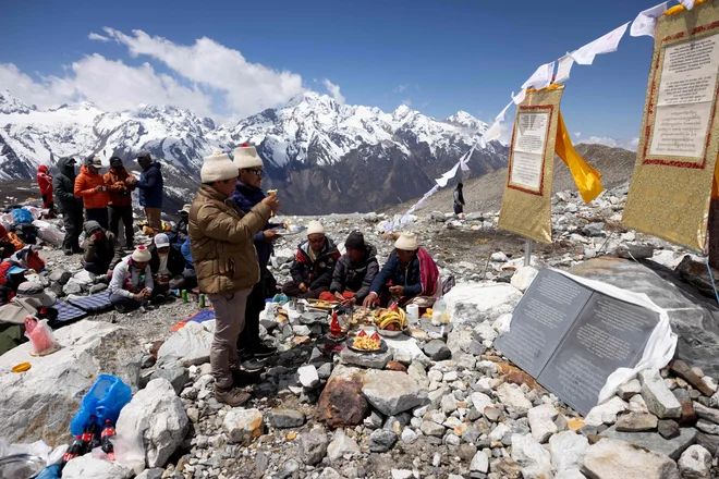 Nepalski menihi izvajajo budistični obred med slovesnostjo v čast ledeniku Yala v dolini Langtang. Več deset ljudi se je včeraj odpravilo na pohod do nepalskega ledenika, da bi se poklonili njegovemu hitremu izginjanju zaradi podnebnih sprememb in opozorili na globalno umikanje ledenikov. Foto: Jitendra Raj Bajracharya/Afp