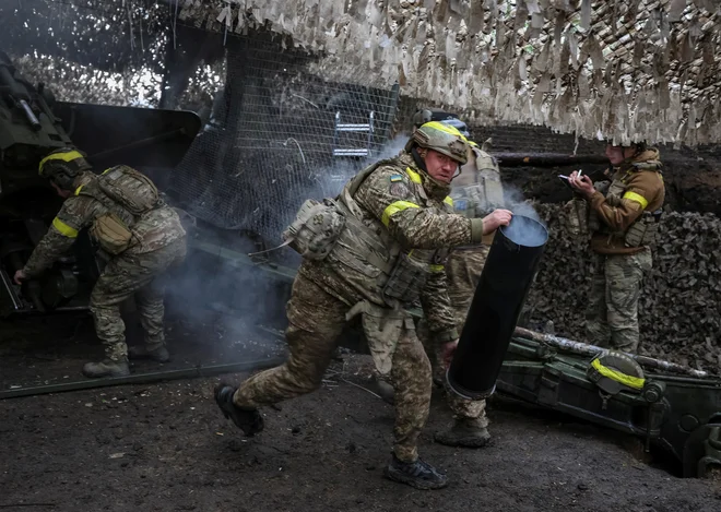 Ukrajinski vojaki med obstreljevanjem ruskih položajev v bližini Kupjanska v Harkovski oblasti na vzhodu Ukrajine. FOTO: Serhii Nuzhnenko/Reuters