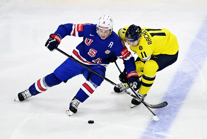 Zach Werenski (ZDA) in Mikael Backlund Pontus Lundah v enem od dvobojev. FOTO: Reuters
