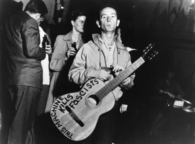 Woody Guthrie z znamenitim napisom na kitari. FOTO: Lester Balog/Woody Guthrie Publications