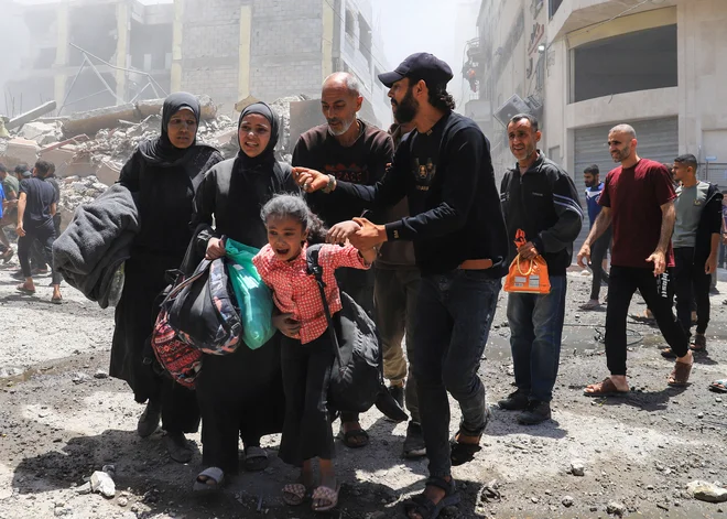 Evakuacija palestinske družine med enim od izraelskih napadov v osrednji Gazi. FOTO: Ebrahim Hajjaj/Reuters