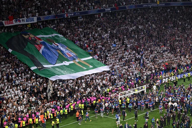 Navijači Paris Saint-Germaina razkazujejo transparent, na katerem je španski trener Luis Enrique skupaj s svojo pokojno hčerko Xano. FOTO: Kirill Kudryavtsev/AFP