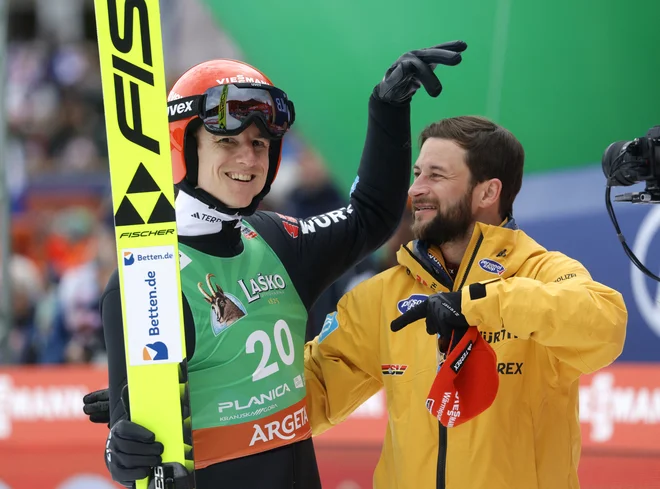Karl Geiger (levo) se je takole konec marca v Planici veselil s poslavljajočim se reprezentančnim kolegom Markusom Eisenbichlerjem. FOTO: Borut Živulović/Reuters
