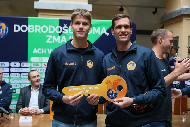 Gregor Ropret (desno) je ob vrnitvi v jato oranžnih zmajev iz rok še enega podajalca Nejca Najdiča prejel oranžen ključ slačilnice ACH Volleyja. FOTO: Črt Piksi