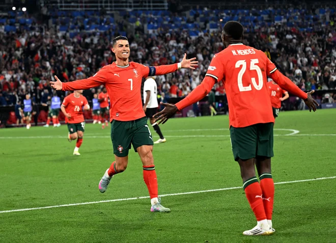 Cristiano Ronaldo (levo) se je takole veselil svojega zmagovitega gola proti Nemcem. FOTO: Angelika Warmuth/Reuters