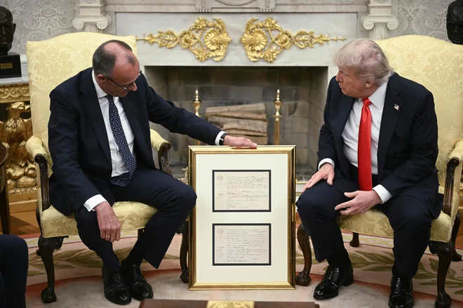Nemški kancler Friedrich Merz je ameriškega predsednika Donalda Trumpa razveselil s prav posebnim dokumentom iz družinske zgodovine. FOTO: Brendan Smialowski/AFP