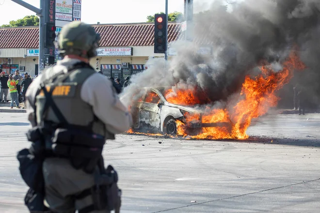 Goreči avto med demonstracijami proti zapiranjem ilegalnih migrantov v Los Angelesu. Foto: Ringo Chiu/Afp