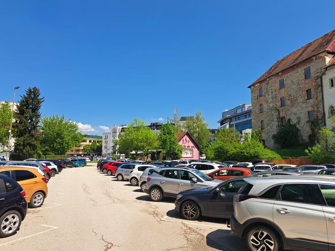 Parkirišče za spodnjim gradom, ki je najbližje mestnemu središču, želi občina nameniti kratkotrajnemu parkiranju. Zaposleni bodo morali vzeti pot pod noge. FOTO: Špela Kuralt/Delo