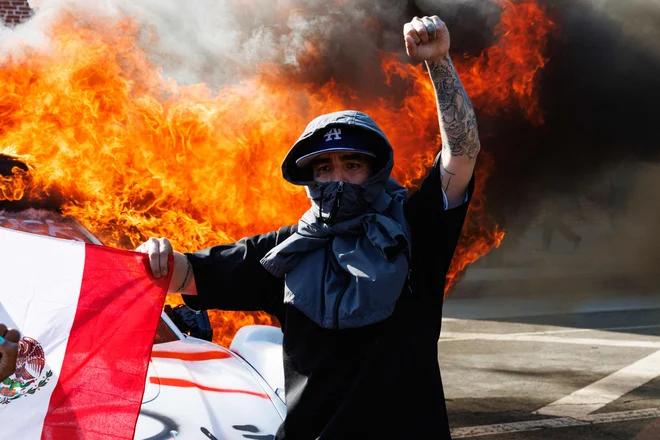 Protestnik z mehiško zastavo v Los Angelesu. FOTO: Blake Fagan/AFP
