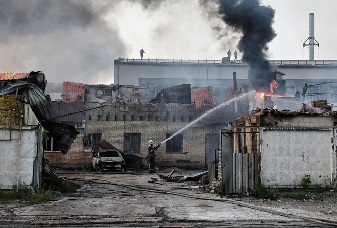 Po napadu so ponekod izbruhnili požari. Prizor iz Kijeva. FOTO: Thomas Peter/Reuters