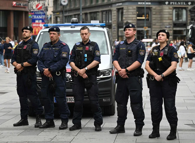 Policisti med minuto tišine za žrtve strelskega pohoda, ki so življenje izgubile v strelskem pohodu v Gradcu. FOTO: Helmut Fohringer/AFP