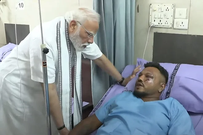 Indijski premier Modi pri edinem preživelem potniku. FOTO: AFP