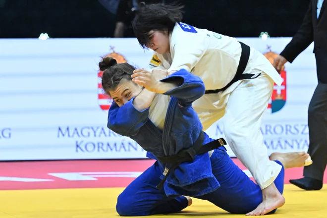 Kaja Schuster (levo) se je enakovredno borila z Japonko Šiho Tanaka. FOTO: Attila Kisbenedek/AFP