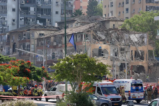 Pogled na uničene stavbe na kraju iranskega raketnega napada v Ramat Ganu v osrednjem Izraelu blizu Tel Aviva. V zadnjih napadih Irana je bilo poškodovanih vsaj 65 ljudi, je sporočila izraelska služba za nujne primere. V kritičnem stanju so 80-letnik in dve 70-letnici, dve drugi osebi sta hudo poškodovani. Več kot 50 ljudi je bilo zaradi šrapnelov poškodovanih med begom v zaklonišča. FOTO: Gil Cohen-magen/Afp