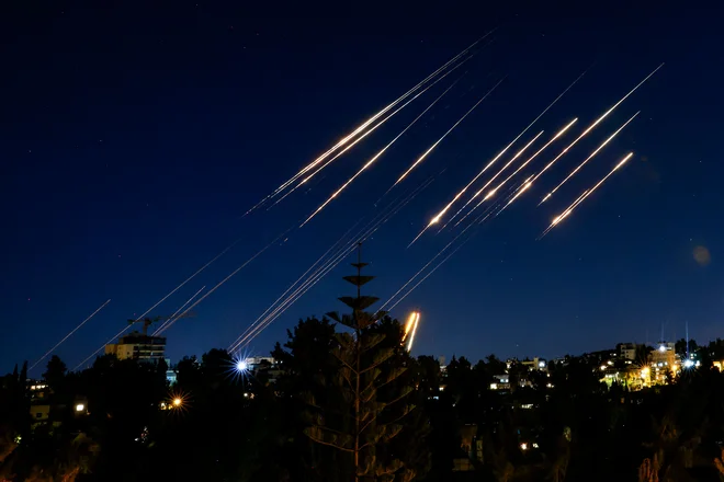 Rakete, izstreljene iz Irana, so vidne na nočnem nebu nad Jeruzalemom 14. junija 2025. FOTO: Menahem Kahana/Afp