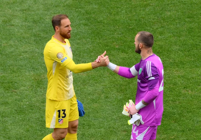 Vratarja Jan Oblak in Stefan Frei sta si čestitala za opravljeno. FOTO: Steven Bisig Imag/Reuters