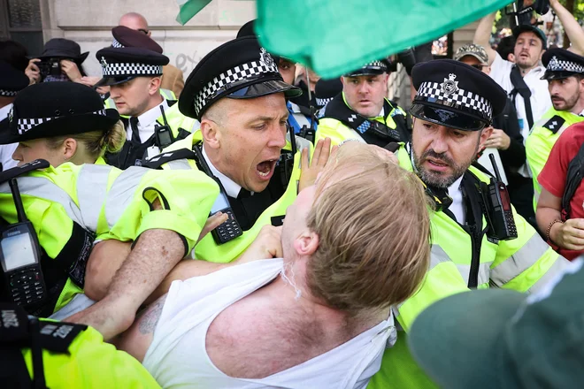 Policisti so se spopadli s protestniki na trgu Trafalgar v središču Londona med shodom v podporo propalestinski skupini Palestine Action, potem ko je britanska vlada napovedala prepoved delovanja skupine. Britanska notranja ministrica Yvette Cooper je včeraj napovedala, da bo prepovedala kampanjo skupine Palestine Action, potem ko so njeni aktivisti prejšnji teden vdrli v največjo letalsko bazo v Združenem kraljestvu. Cooperjeva je dejala, da je bilo vandaliziranje dveh letal na letališču RAF Brize Norton v južni Angliji 20. junija sramotno, skupina pa ima dolgo zgodovino nesprejemljivega vandalizma. Foto: Henry Nicholls/Afp