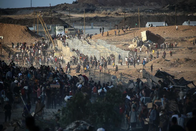 Palestinci se zbirajo na točki razdeljevanja pomoči, ki jo je v bližini begunskega taborišča Nuseirat v osrednjem delu območja Gaze vzpostavila zasebna humanitarna fundacija Gaza. Foto: Eyad Baba/Afp