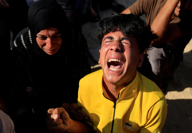 Žalujoči med pogrebom Palestincev, ubitih v nočnem izraelskem napadu na šotor. FOTO: Hatem Khaled/Reuters