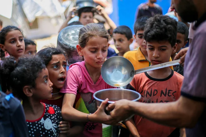 Palestinski čakajo na hrano v begunskem taborišču Nuseirat v Gazi FOTO: Eyad Baba/Afp