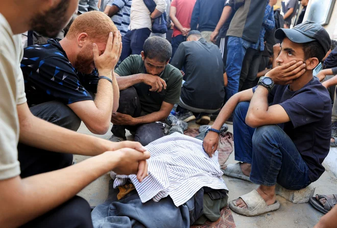Pogreb ubitih v napadih na šolo, ki je služila kot zatočišče preseljenim Palestincem, in tisith, ki so padli pod streli, medtem ko so čakali na pomoč. FOTO: Dawoud Abu Alkas/Reuters