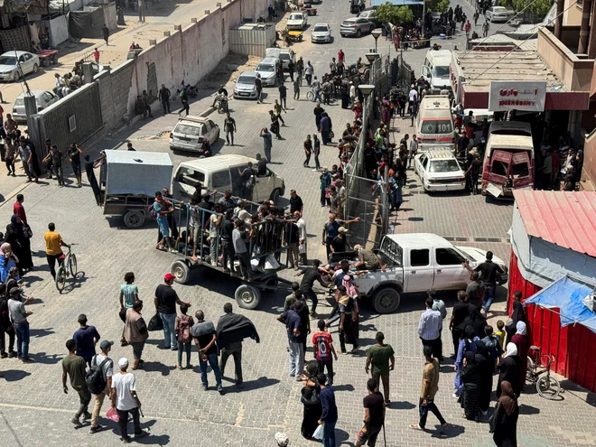 Palestinci prenašajo žrtve streljanja na eni od točk za razdeljevanje pomoči. FOTO: Stringer/Reuters