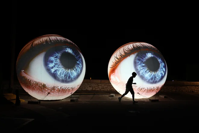 Obiskovalec se sprehaja mimo svetlobne projekcije med 10. festivalom svetlobe Festi Lumi v starem mestecu Bonifacio na francoskem sredozemskem otoku Korzika. Foto: Pascal Pochard-casabianca/Afp