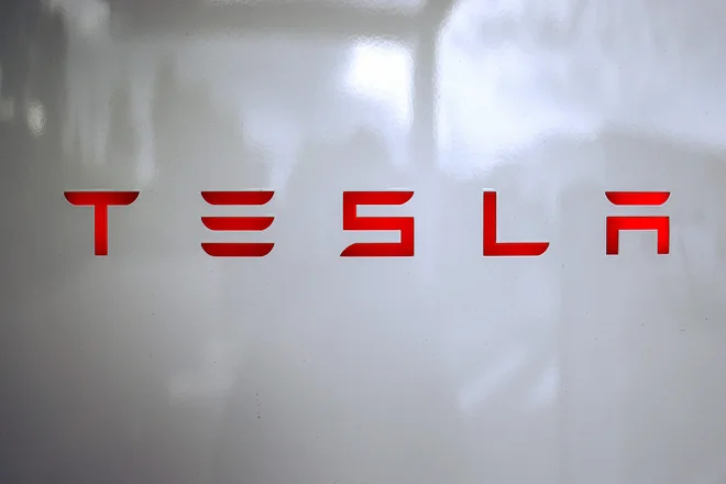 Logo podjetja Tesla. FOTO: Alex Martin/AFP