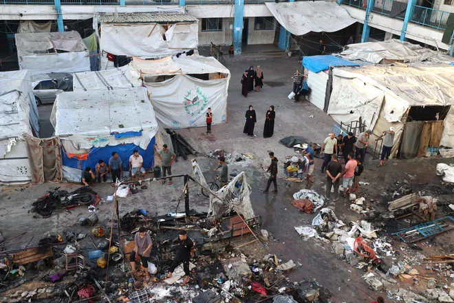 Pregledovanje škode po izraelskem napadu na šolo, kamor so se zatekli preseljeni Palestinci FOTO: Eyad Baba/AFP