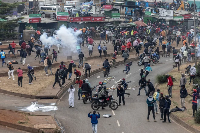 Protestniki stojijo med oblaki solzivca, ki so ga izstrelili kenijski policisti med spopadi na demonstracijah ob dnevu Saba Saba v Nairobiju. Kenija je včeraj obeležila svoj boj za demokracijo s policijsko blokado glavnih cest v Nairobiju pred morebitnimi protesti, potem ko so se demonstracije prejšnji mesec sprevrgle v nasilne spopade. Dan Saba Saba zaznamuje upor 7. julija 1990, ko so Kenijci zahtevali vrnitev večstrankarske demokracije po letih avtokratske vladavine takratnega predsednika Daniela arapa Moija. Foto: Simon Maina/Afp