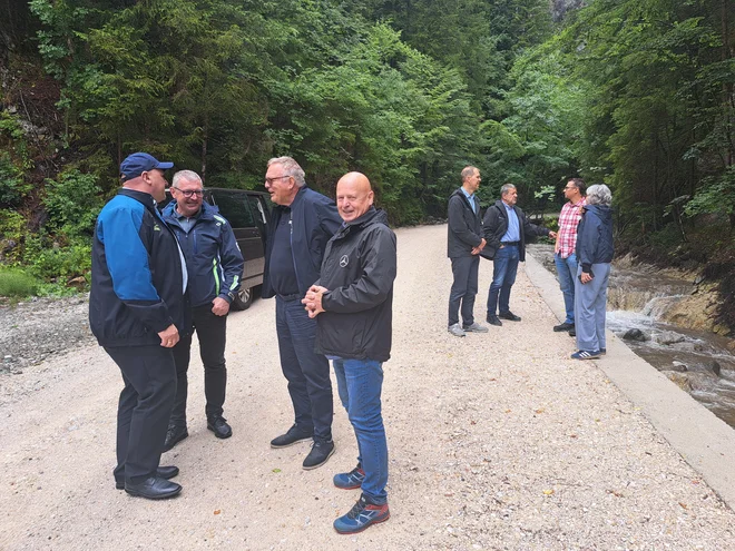 Minister Jože Novak (tretji z leve) si je na terenu ogledal, kaj so naredili v Šaleški dolini in ob potoku Ljubija po katastrofalni poplavi leta 2023. FOTO: Špela Kuralt/Delo