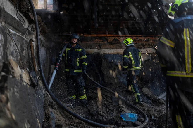 Gasilci 10. julija 2025 gasijo požar v stanovanjski hiši v Kijevu po ruskem napadu FOTO: Oleksii Filippov/AFP
